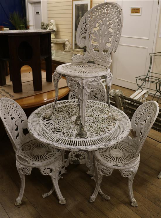 A set of four white painted cast aluminium Coalbrookedale style garden chairs and a matching table